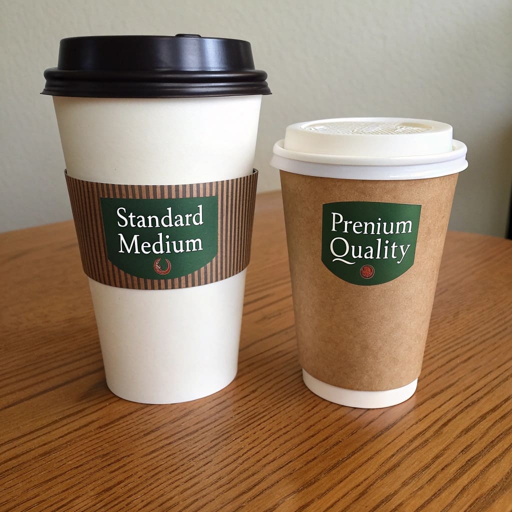 A 12oz chain coffee cup next to a smaller 8oz specialty coffee cup